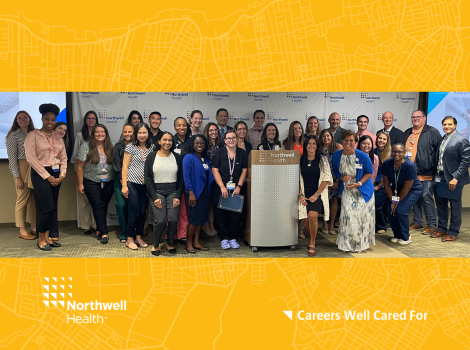 A large group of Northwell team members standing together in front of a large Northwel Health backdrop.